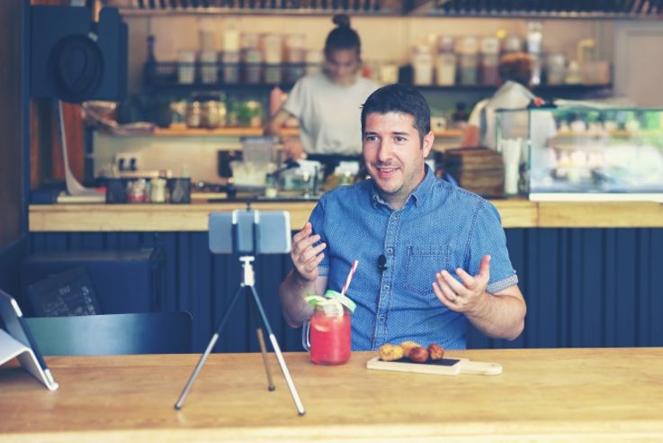 Social media influencer or food blogger creating content inside small restaurant